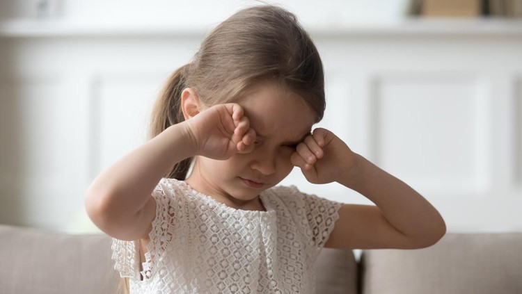 Ilustrasi Mata Tiroid pada Anak Sleepy stressed tired upset little child crying rubbing eyes feel abused hurt pain, sad lonely worried preschool kid girl in tears miss parents sitting on sofa alone, unhappy children emotion concept