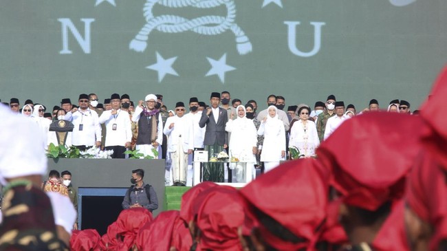 Erick Thohir memamerkan baju Banser di depan Presiden Jokowi yang hadir di Harlah 1 Abad NU. Ia menyatakan Nahdliyin siap berkarya untuk bangsa.