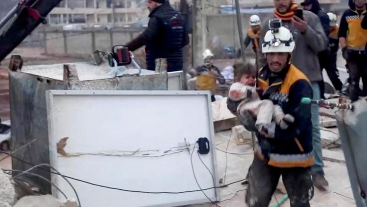Momen Evakuasi Bocah Korban Gempa di Suriah A rescue worker carries a child at the site of a damaged building, following an earthquake, in rebel-held Azaz, Syria February 6, 2023. REUTERS/Mahmoud Hassano