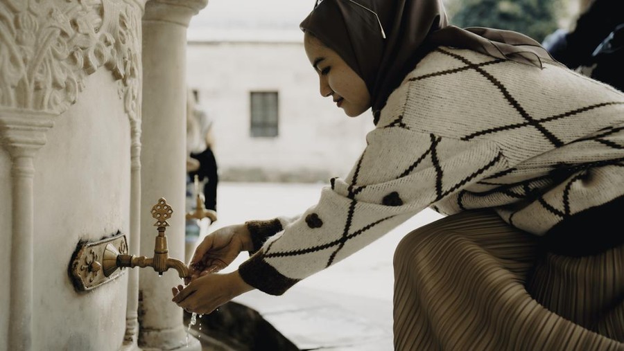 Muslim woman taking ablution for prayer