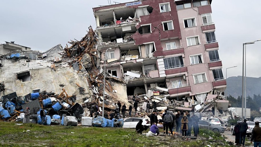 HATAY, TURKIYE - FEBRUARY 06: A view of a collapsed building in Hatay, Turkiye after 7.7 and 7.6 magnitude earthquakes hits Turkiye's Hatay, on February 06, 2023. Disaster and Emergency Management Authority (AFAD) of Turkiye said the 7.7 magnitude quake struck at 4.17 a.m. (0117GMT) and was centered in the Pazarcik district and 7.6 magnitude quake struck in Elbistan district in the province of Kahramanmaras in the south of Turkiye. Gaziantep, Sanliurfa, Diyarbakir, Adana, Adiyaman, Malatya, Osmaniye, Hatay, and Kilis provinces are heavily affected by the earthquakes. (Photo by Ercin Erturk/Anadolu Agency via Getty Images)