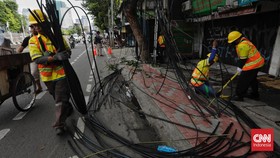 Petugas Dinas Bina Marga DKI Jakarta menertibkan kabel udara di Jalan Mampang Prapatan. Jakarta, Senin, 13 Februari 2023. (CNN Indonesia/Adhi Wicaksono)