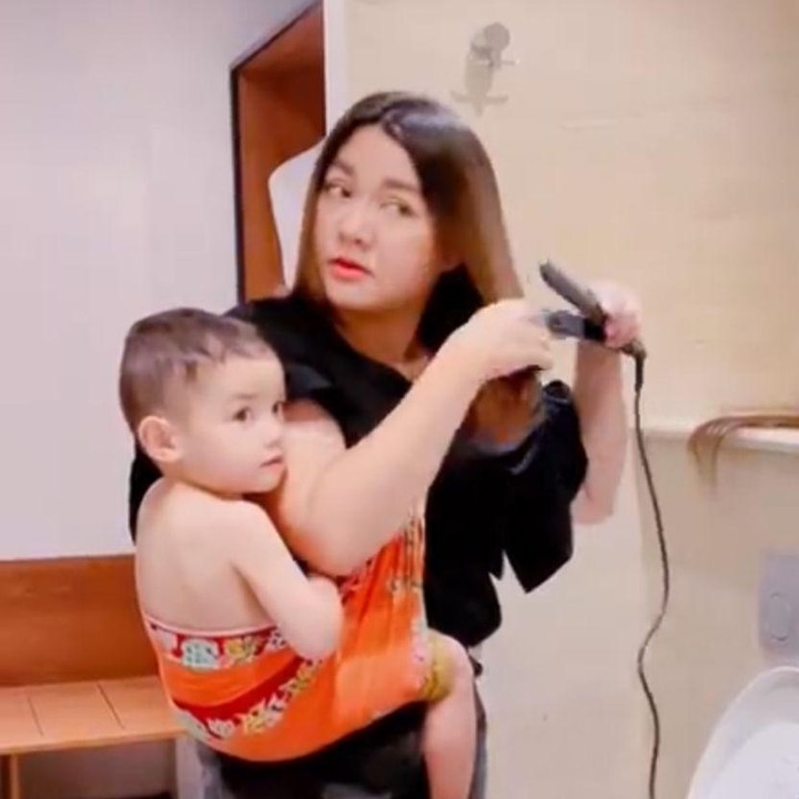 <p>Vicky Shu selalu bisa membagi waktu antara menjaga sang anak dengan pekerjaan, Bunda. Di salah satu posting-annya, Vicky bahkan bisa menggendong sang anak dengan kain jarik sekaligus mencatok rambut. (Foto: Instagram: @vickyshu)</p>