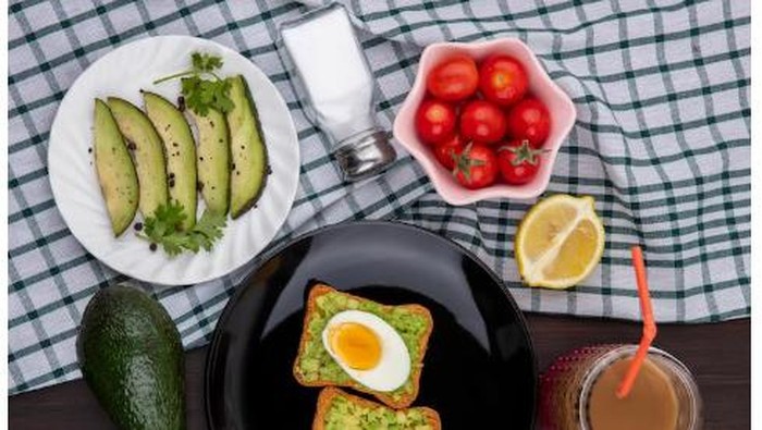 Roti bakar topping alpukat dan telur setengah matang/Foto:freepik/stockking