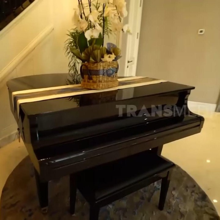<p>Untuk yang satu ini mungkin sudah tak asing lagi, nih, Bunda. Pasalnya, area dengan piano hitam yang terletak tepat di dekat tangga ini sering digunakan beberapa <em>influencer</em> untuk membuat konten di media sosial. Influencer yang paling sering membuat konten di rumah aktris cantik ini adalah Fuji dan Fadly. (Foto: YouTube TRANS7 OFFICIAL)</p>