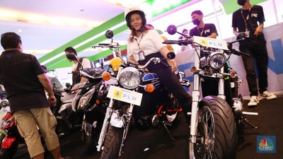 Pengunjung melihat motor lawas yang di konversi menjadi motor listrik pada booth PLN dalam ajang pameran otomotif Indonesia International Motor Show (IIMS) 2023 pada Sabtu (18/2/2023). (CNBC Indonesia/Tias Budiarto)