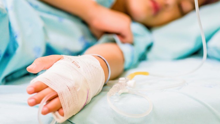 Closeup kid hand  sleeps on a bed in hospital with saline intravenous.