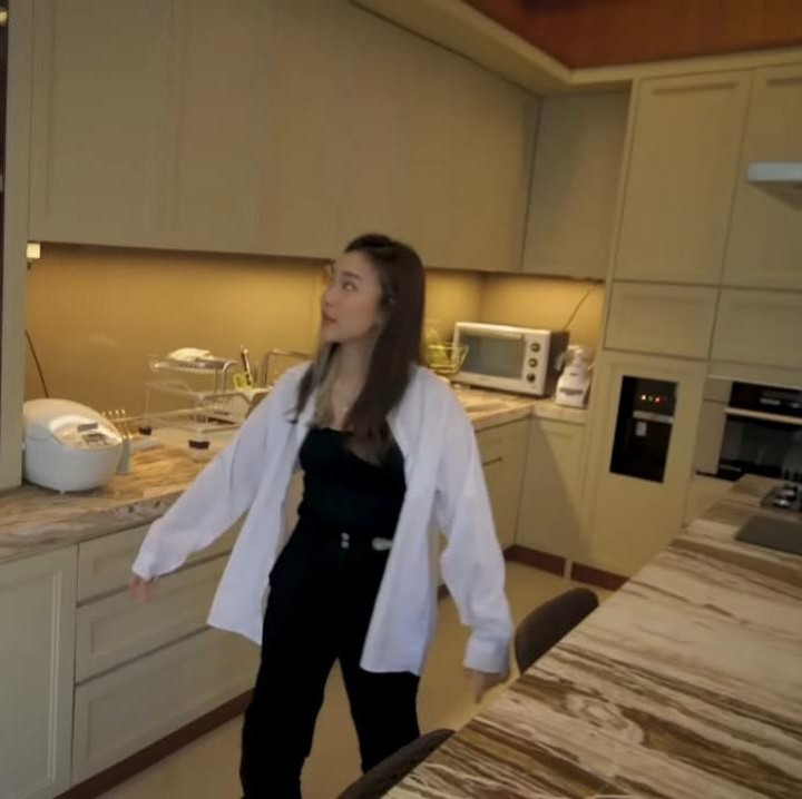 <p>Untuk dapur, Jessica memilih nuansa putih untuk <em>kitchen set</em>-nya dan marmer berwarna cokelat untuk meja di dapurnya yang sering digunakan sebagai meja makan. (Foto: YouTube Jessica Jane)</p>
