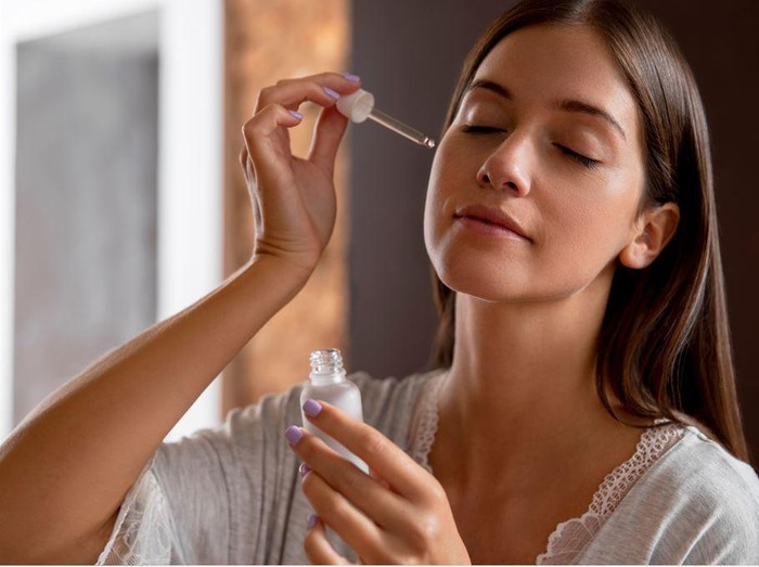 Ilustrasi perempuan memakai serum di wajah/ Foto: freepik.com