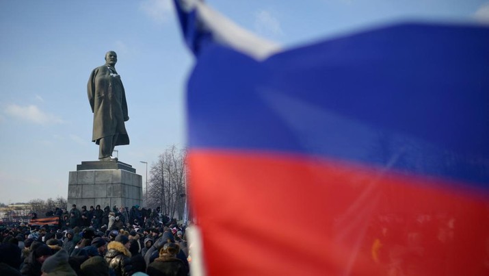Orang-orang berkumpul di dekat monumen pendiri Uni Soviet Vladimir Lenin saat mereka tiba untuk konser patriotik yang didedikasikan untuk Hari Pembela Tanah Air yang akan datang di stadion Luzhniki di Moskow pada 22 Februari 2023. (AFP via Getty Images/NATALIA KOLESNIKOVA)