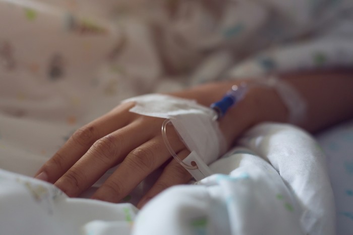 medical infusion iv drip saline solution in hand patient illness unwell