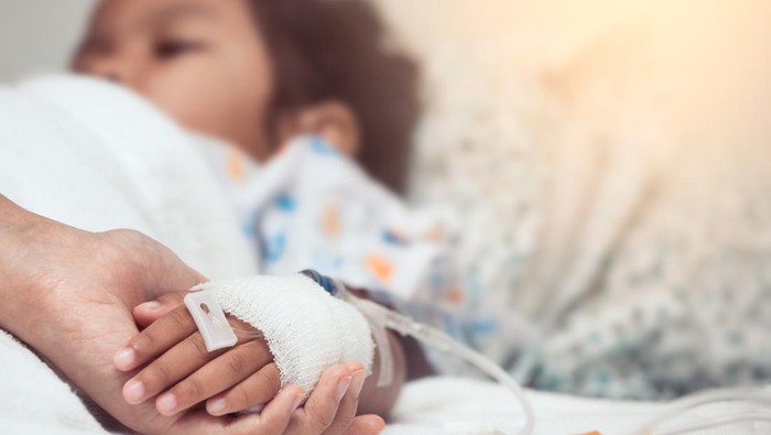 Mother hand holding child hand who have IV solution in the hospital with love and care