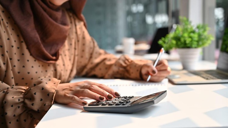 1141594590 Islam woman working with finance calculate on calculator.