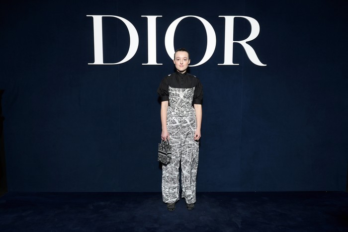 Bella Ramsey dari serial The Last of Us (2023) tampil stylish memakai kemeja dan overall lansiran Dior yang mana berhiaskan ilustrasi peta kota Paris.Foto: Getty Images for Christian Dior/Pascal Le Segretain