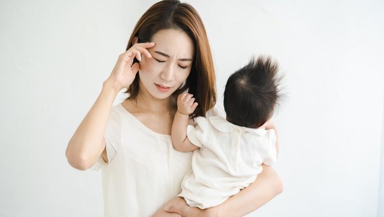 Ilustrasi Penyebab Ibu Baru Alami Kecemasan Asian mother holding a baby and looking tired