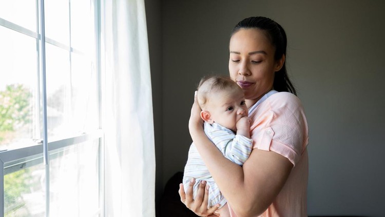 Ilustrasi Tips Parenting Jadi Orang Tua Baru Mother stares at newborn baby while standing near window at home