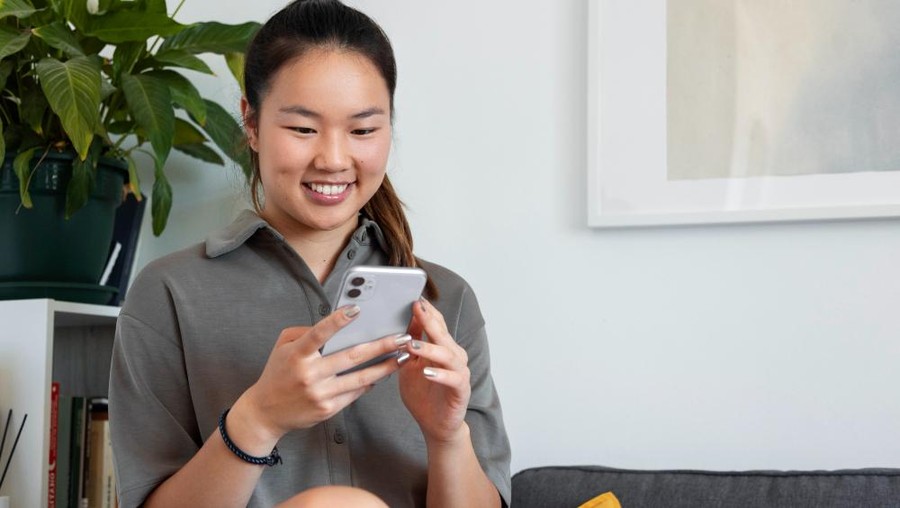 Ilustrasi perempuan memakai handphone/Foto: freepik/freepik