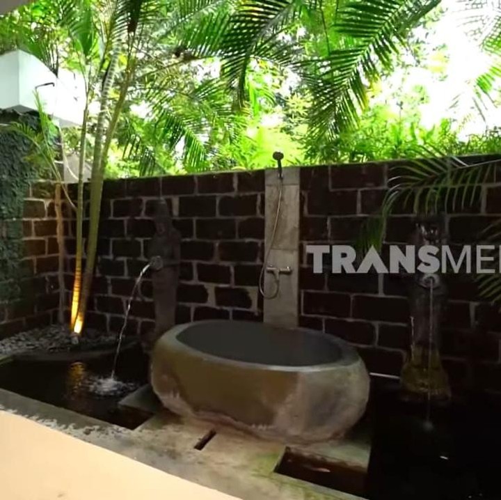 <p>Bagian unik lainnya dari rumah Indah yang satu ini adalah kamar mandinya yang menggunakan konsep menyatu dengan alam. Jika biasanya kamar mandi selalu memiliki area yang tertutup, kamar mandi pengusaha yang satu ini berbeda, Bunda. Indah lebih memilih kamar mandi terbuka dengan banyak tanaman yang menghiasinya. Meski begitu, kamar mandinya ini aman, <em>kok,</em> Bunda. (Foto: YouTube TRANS7 OFFICIAL)</p>