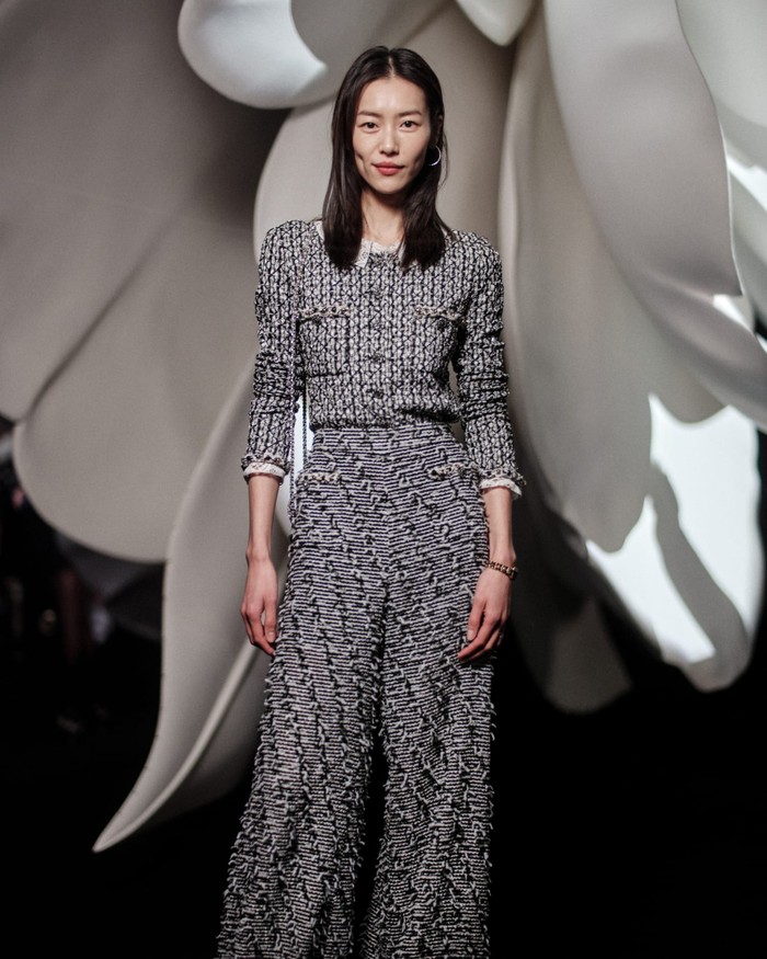Simple but chic! Supermodel Liu Wen memadukan jaket crop dan celana high waisted yang kaya akan detail. Terlihat subtle berkat pilihan warna senada.Foto: Courtesy of Chanel