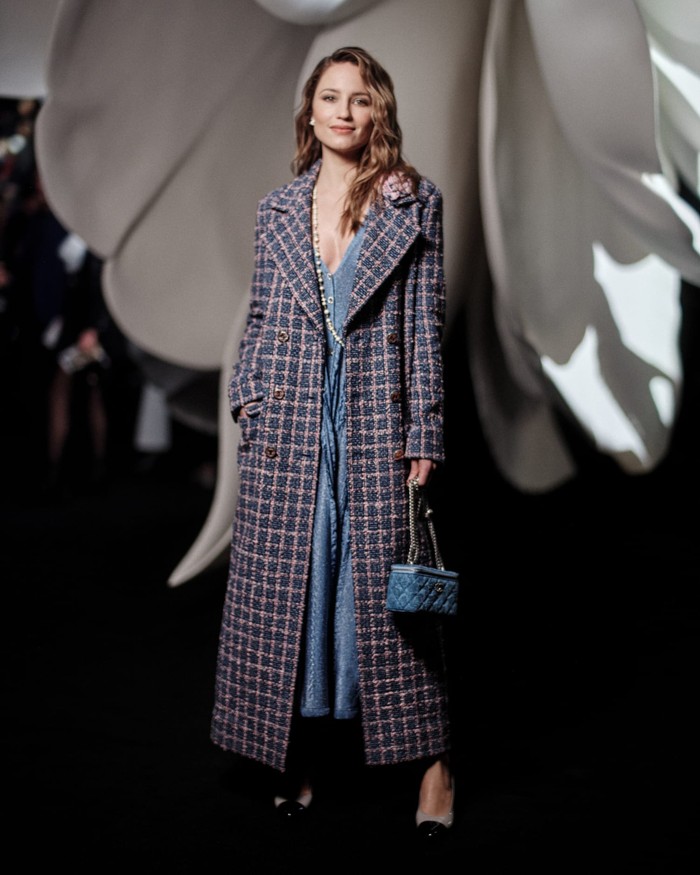 Buat denim dress jadi lebih chic dengan mengenakannya bersama oversized coat bermotif check dalam warna pastel seperti Diana Agron berikut. Foto: Courtesy of Chanel
