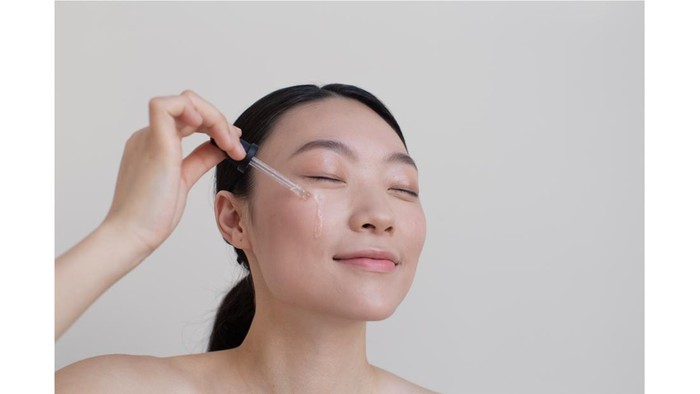 ilustrasi tengah mengaplikasikan serum pada wajah