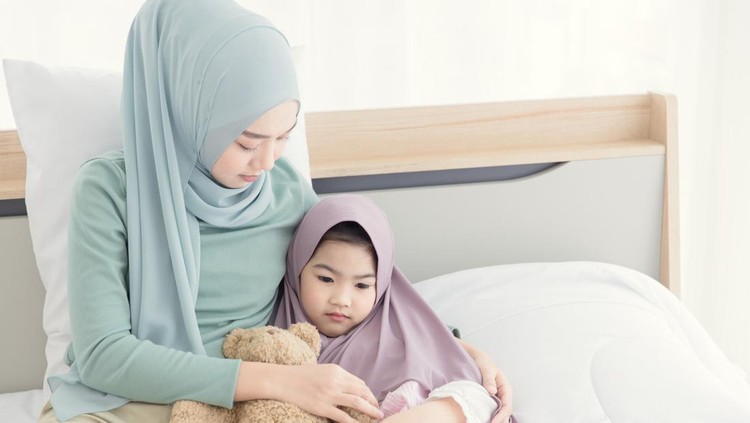 Muslim mother consoling cry and depress little child from being bullied and hate to go to school.