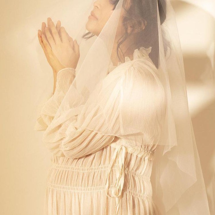 <p>Rinni memperlihatkan baby bump kehamilan keduanya di maternity shoot kali ini. Rinni terlihat glowing mengenakan gaun krem muda dengan veil menutupi kepalanya. (Foto: Instagram @rinni_w)</p>