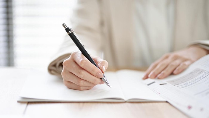 Hands of an Asian woman studying in a coworking space