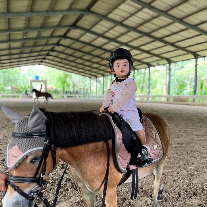 <p>Baby Guzel kerap diajak menunggangi kuda bersama kedua orang tuanya, nih. Tanpa rasa takut, Guzel naik ke atas kuda di arena stable. (Foto: Instagram @guzelimalisyakieb)</p>