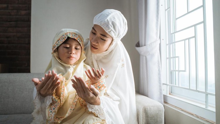 Ilustrasi Tips agar Anak Kuat Berpuasa Seharian mother teach her daughter to pray with her hand open palm