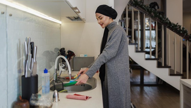 Young Caucasian White attractive, long-haired woman in the kitchen.