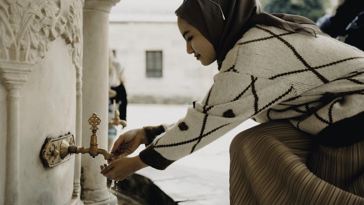 Muslim woman taking ablution for prayer
