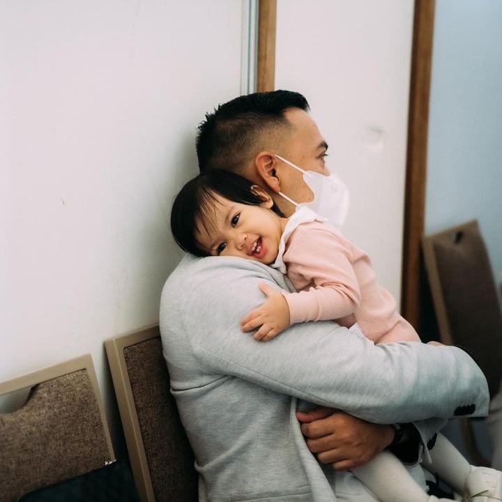 <p>Pemandangan yang membuat hati meleleh ya, Bunda. Nakeeya is the little dady's girl nih. Kelihatan nyaman banget ya digendongan Ayah Baldy. (Foto: Instagram @riafinola)</p>