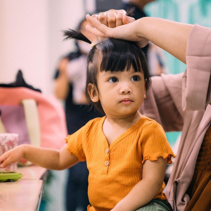 <p>Menyandang predikat sebagai anak bontot memang membuat Nakeeya selalu diajak kemana saja. Salah satunya seperti mengikuti sang bunda bekerja seperti kali ini. Rambutnya yang tumbuh lebat tampak dikuncir lucu di atas kepalanya. (Foto: Instagram @riafinola)</p>