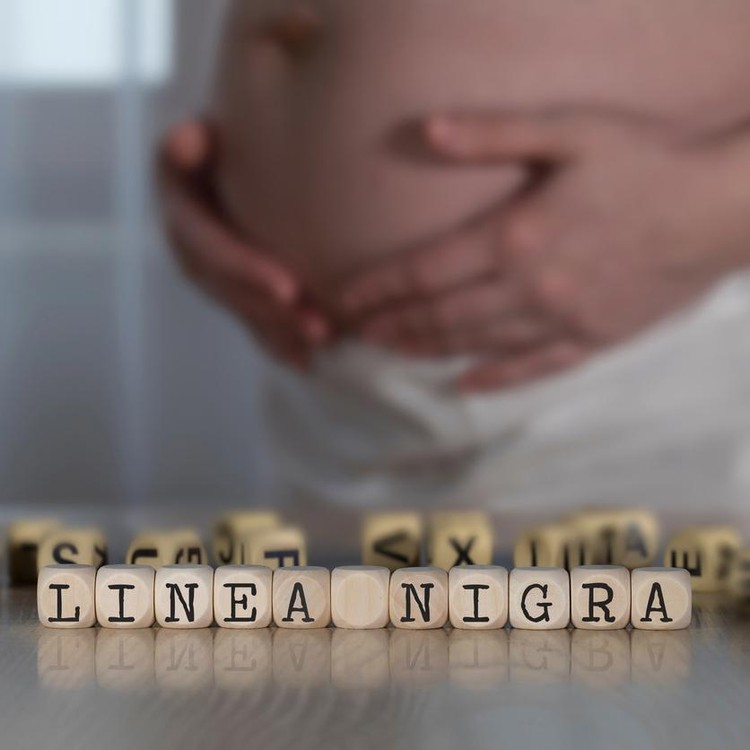 Ilustrasi linea nigra pada ibu hamil Words LINEA NIGRA for Black Line composed of wooden letters. Pregnant woman in the backgroundIlustrasi Linea nigra pada ibu hamil
