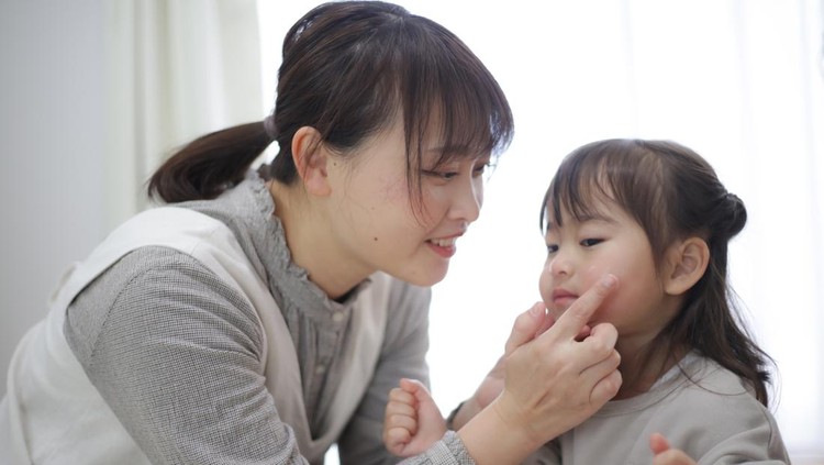 Ilustrasi Pytriasis Alba pada Anak Parent and child applying moisturizing cream