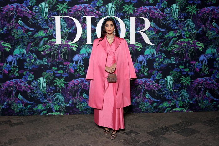 Gaun dan mantel pink yang feminin makin modis dan glamor lewat tambahan perhiasan yang bold seperti ditampilkan Sonam Kapoor. Foto:Getty Images/ Courtesy of Dior