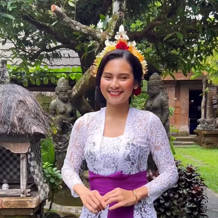 <p>Indah Permatasari menjelma menjadi gadis Bali dalam balutan kebaya warna putih, lengkap dengan aksesori rambut dan selendang di pinggangnya. (Foto: Instagram @indahpermatas)</p>