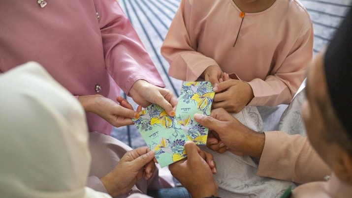 Young kids receiving gift money from parents as part of the Islamic celebration of Hari Raya Aidilfitri (Eid al-Fitr)