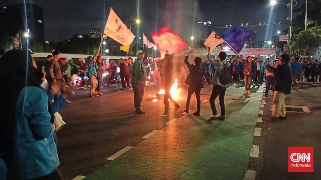 Mahasiswa membakar ban dan menutup jalan depan Gedung DPR saat demonstrasi menolak UU Cipta Kerja pada Rabu sore (5/4).