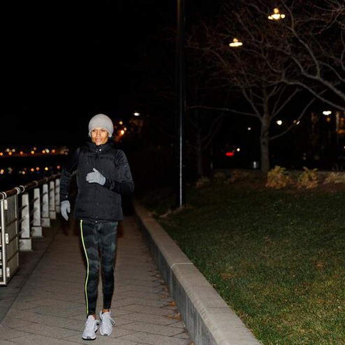 Gambar perempuan berolahraga di malam hari.