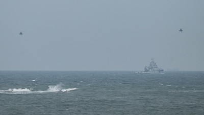 Dua helikopter militer China terbang melewati kapal tunda Angkatan Laut PLA, seperti yang terlihat dari pulau Pingtan, titik terdekat ke Taiwan, di provinsi Fujian tenggara China pada 7 April 2023. Dua helikopter militer China terbang melewati kapal tunda Angkatan Laut PLA, seperti yang terlihat dari pulau Pingtan, titik terdekat ke Taiwan, di provinsi Fujian tenggara China pada 7 April 2023. (GREG BAKER/AFP via Getty Images)