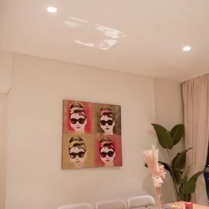 <p>Meski simpel, Melaney tetap ingin apartemennya terlihat lebih hidup. Ia pun sengaja memasang lukisan di area meja makan. (Foto: YouTube Ayu Dewi)</p>
