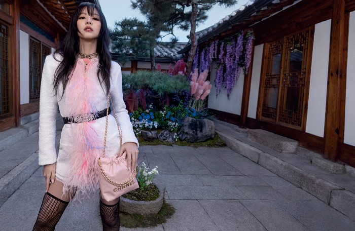 Jenni tampil feminin mengenakan gaun aksen feathers dan tas Chanel 22 terbaru yang kini hadir dalam ukuran mini. Foto: Inez and Vinoodh/Courtesy of Chanel