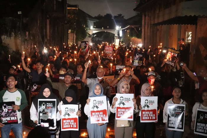 Ratusan suporter di Surabaya menggelar aksi solidaritas 1.000 lilin dan doa bersama untuk sepak bola Indonesia. Begini potretnya.
