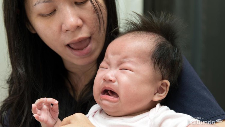521623102 Mother is trying to comfort crying baby