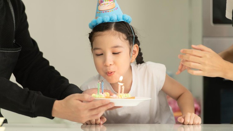 Ilustrasi Dampak Anak Meniup Lilin New generation asian family cook together and organize a small birthday party for our little daughter in the kitchen of the house