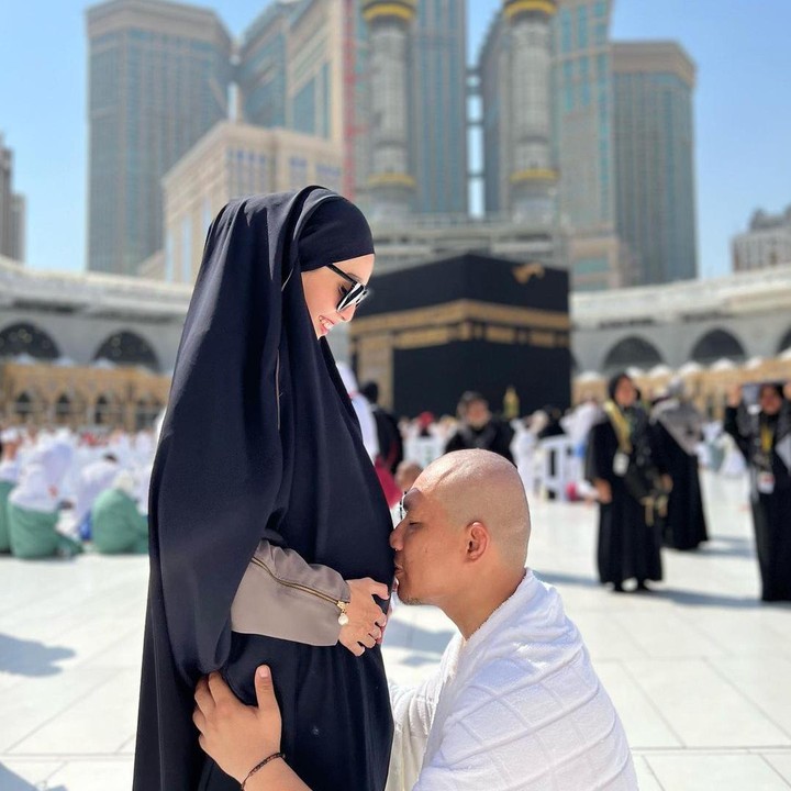 <p>Monica Imas yang sedang hamil dan suaminya, Rizal Armada berfoto di sela-sela melakukan ibadah umroh di Tanah Suci. Rizal tampak mencium perut hamil istrinya sebagai tanda kasih sayang kepada anak ketiganya. (Sumber Instagram: @monicaimas)</p>
