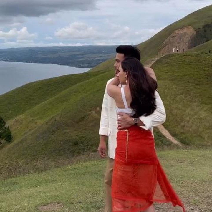 <p>Selain pakaian adat, Jessica dan Yakub juga mengenakan pakaian modern bernuansa putih. Meski beda konsep dengan sebelumnya, pasangan ini tetap memilih berfoto dengan pemandangan indah Danau Toba. (Foto: Instagram @jscmila)</p>