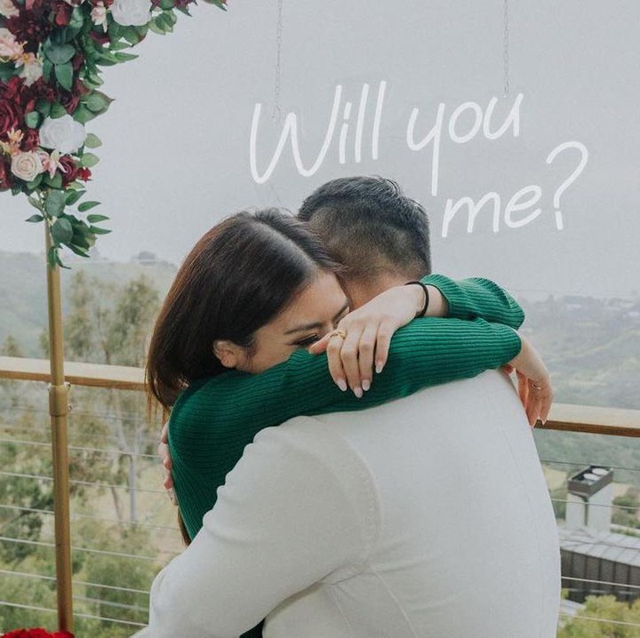 <p>Dalam potret yang dibagikan, Clarissa dan Anthony tampak saling tersenyum dan memandang satu sama lain di sebuah balkon. Keduanya lalu berpelukan tanda lamaran diterima. Di sekitar mereka juga tampak dekorasi cantik dengan bertabur bunga. (Foto: Instagaram @clarissatanoe)<br /><br /><br /></p>